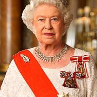 Wearing a tiara with matching shiney necklace, a sash and medals, the white haired queen looks unsmilingly at the camera.