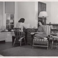 Black and white historic image of two people studying quietly in a neat room