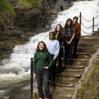 Students standing on a staircase overlooking a rushing waterfall