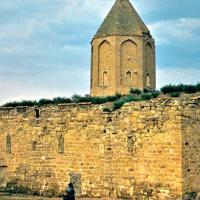 Old stone building with a tower; grass growing on roof