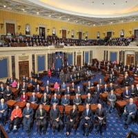 The U.S. Senate chamber (blue carpet, yellow walls) with the Senators seated at their deks