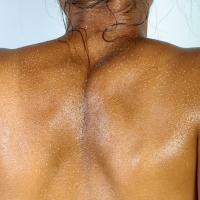 Person's back, covered with water droplets
