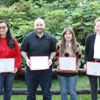 four people holding certificates