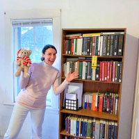  A graduate student smiles in front of all her books