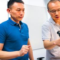 Two people look at a piece of equipment