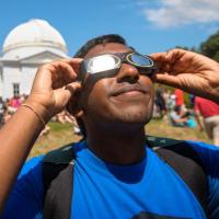 Student observing solar eclipse with special glasses