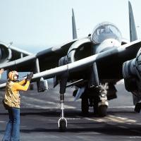 Person on tarmac next to fighter jets
