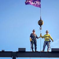 Two ironworkers on top of a beam
