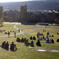 Students sit on a grass slope