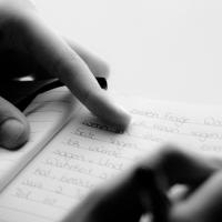  woman&#039;s hands writing in a notebook