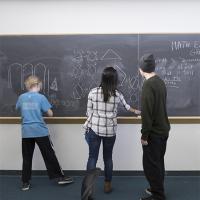 High school kids work at a chalkboard