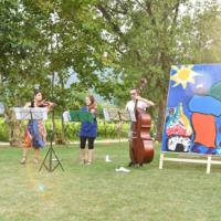 Kim and refugees playing music in a field