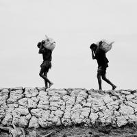  Image of of two boys carrying a load 