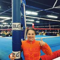  woman standing by boxing ring giving thumbs up