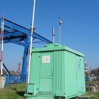 An air pollution measuring station, with a long pole rising above it to test the air.