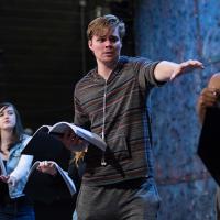 Student rehearsing a play on lit stage