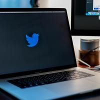 Laptop showing blue bird Twitter logo on a black screen