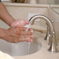 hands under a faucet with soap