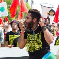 Person holding megaphone with crowd behind
