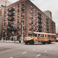Big brick building in New York City with school bus in front of it