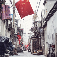 Narrow street with a red Chinese flag hanging