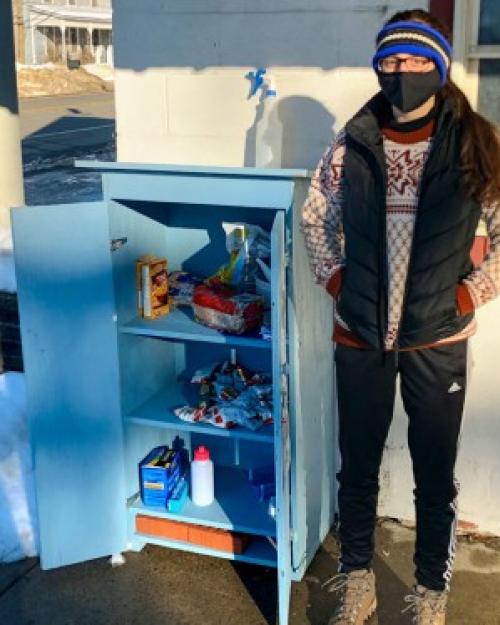Person standing next to an outdoor food cupboard