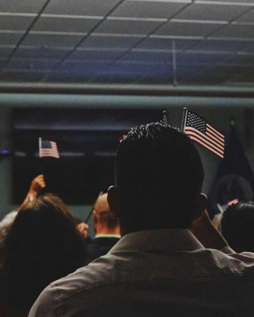 People holding small American flags in a classroom