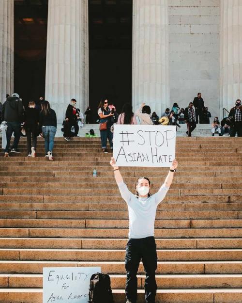 Person holding protest sign on steps