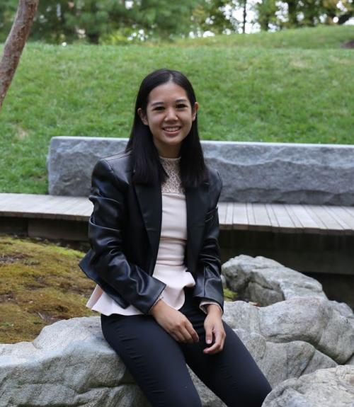 Grace Tran sitting against a nature background. 