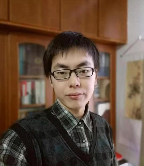 Zhiyuan Zhou in front of a book case.