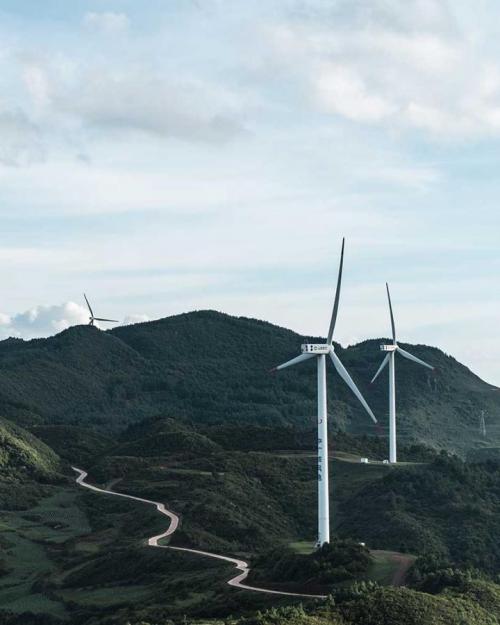 Wind turbines in a green, hilly landscape