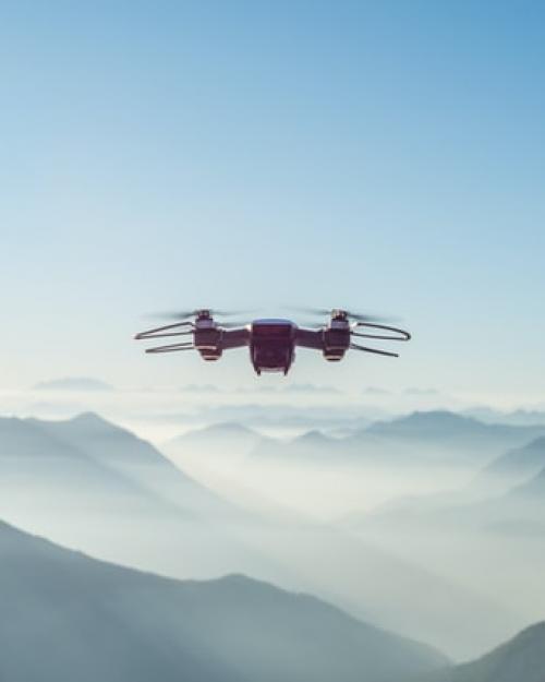 Drone flying in the air with mountains in the background
