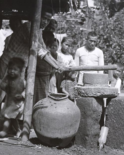 Several people stand near a well