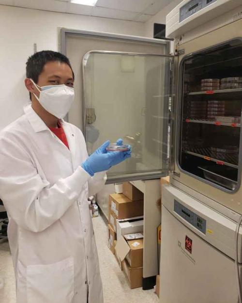 man with petri dish in lab