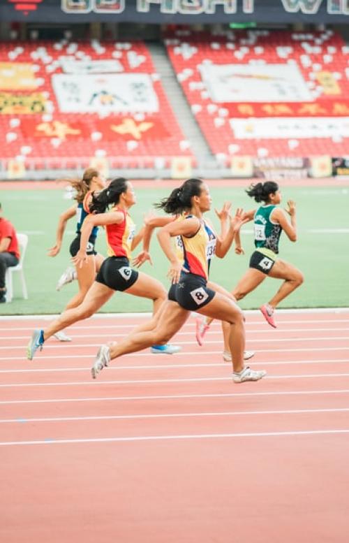 		Women runners competing around a track.
	