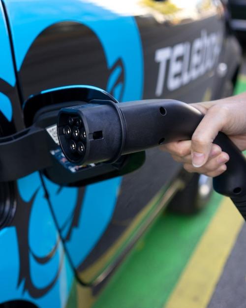 Hand holding electric charger to car