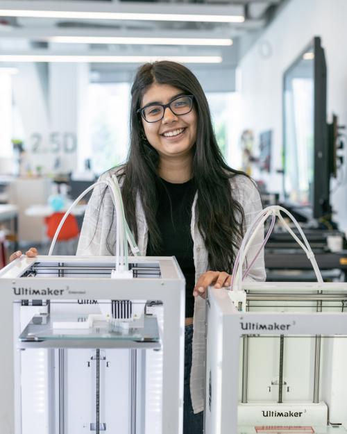 student standing behind a 3D printer