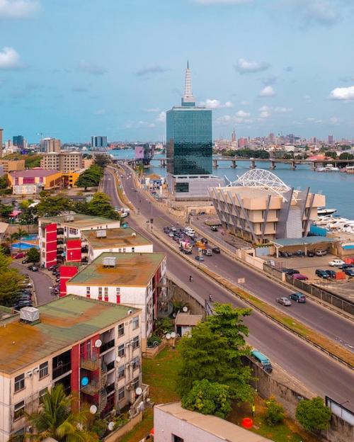 City street winds past modern buildings beside a river: Lagos, Nigeria