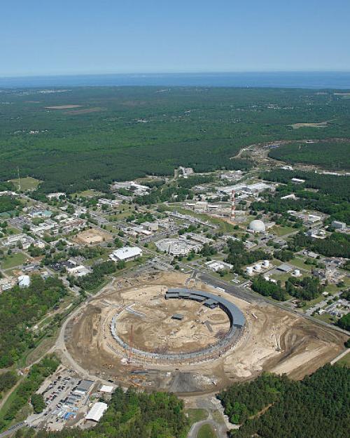 The circular accelerator ringed by buildings surrounded by a vast area of solid trees
