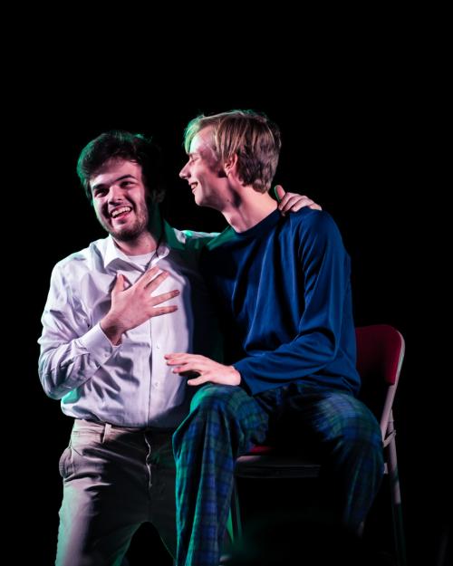 two people laughing on stage
