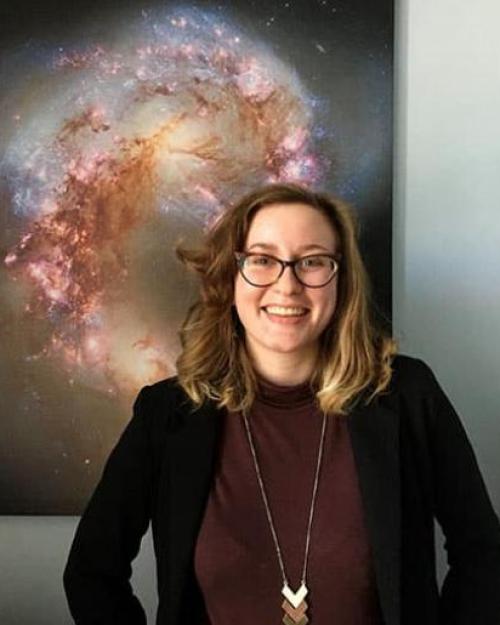 		Person standing in front of a poster showing outer space
	
