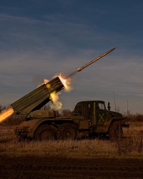 Military vehicle firing a missile while parked in a field