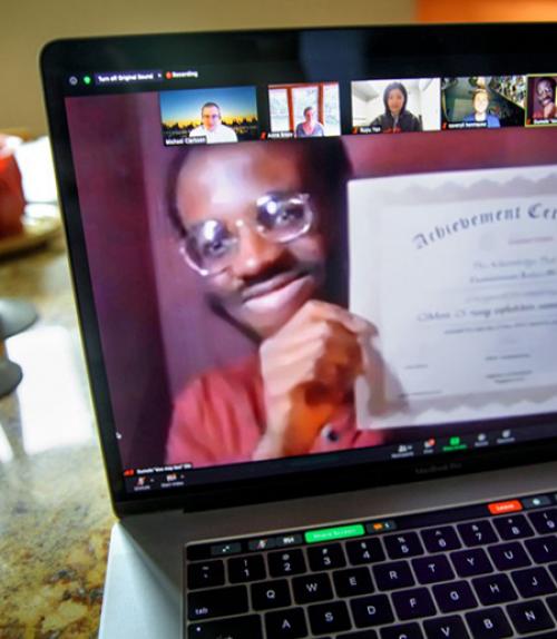 Person on computer screen, holding up a certificate