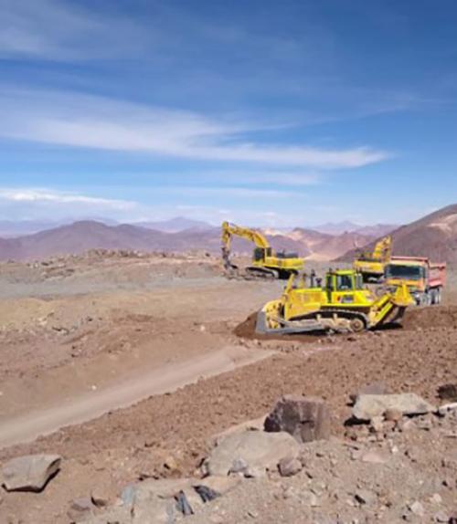 Bulldozers at the site of the telescope, with mountains in the background
