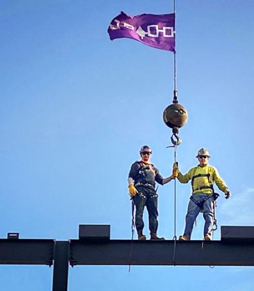  Two ironworkers on top of a beam