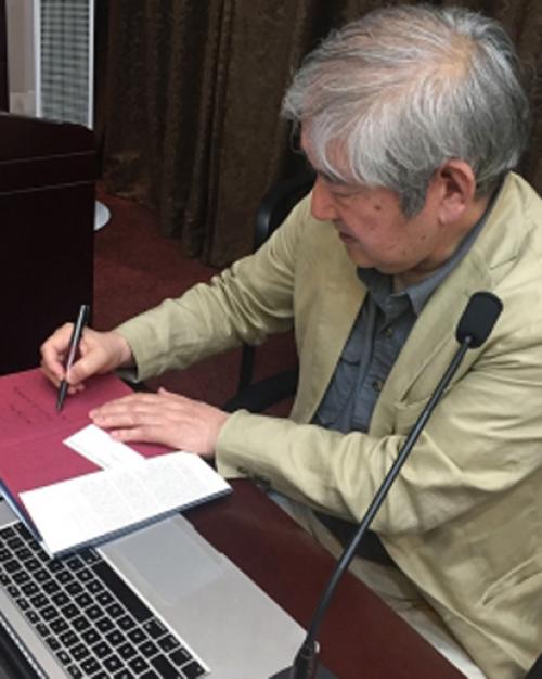Someone in the China Summer School signing a paper