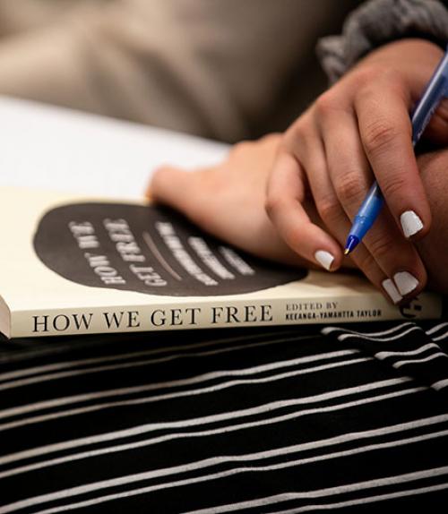  The book &quot;How We Get Free&quot; on someone&#039;s lap