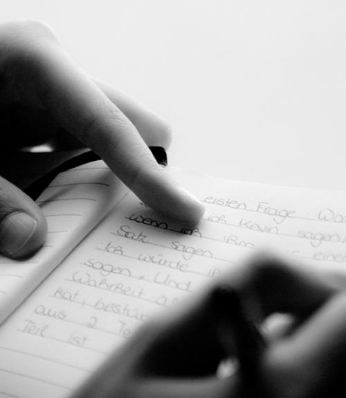 woman&#039;s hands writing in a notebook