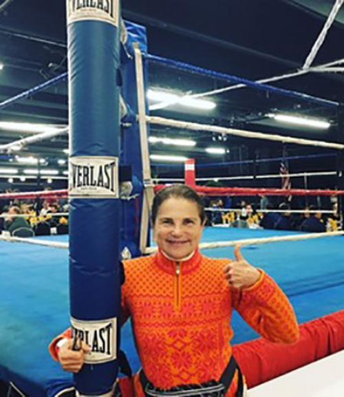  woman standing by boxing ring giving thumbs up