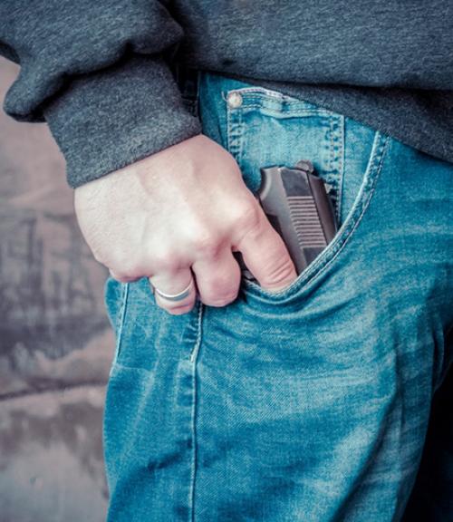  Hand touching gun in jeans pocket